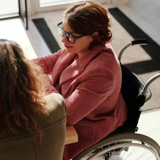 Accessible therapy session with a woman in a wheelchair engaging with a caregiver.