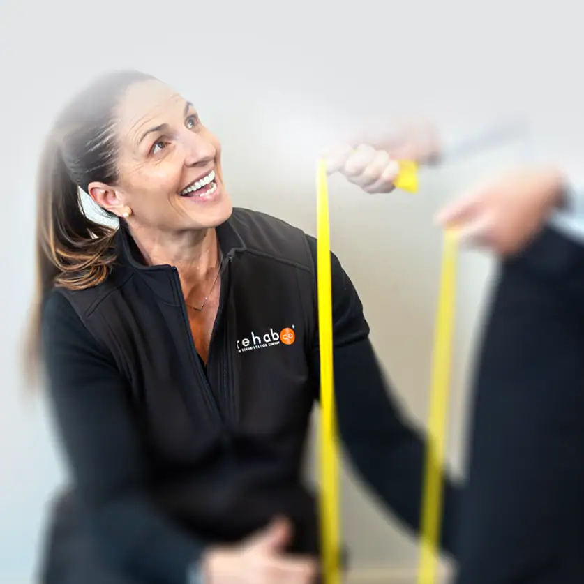 Physiotherapist measuring patient with tape at Rehab Co clinic.