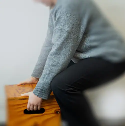 Person performing balance exercise on wooden box for rehab and strength training.