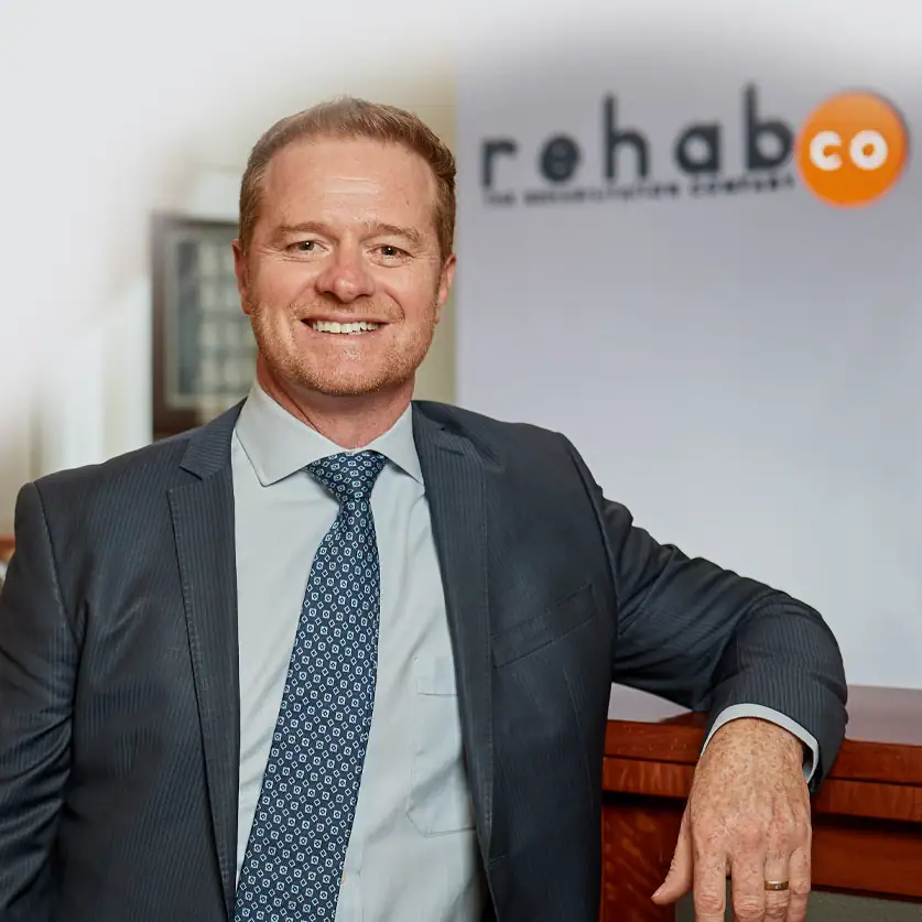 Professional team member at Rehab Co office in business attire.