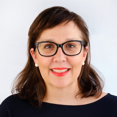Rehab Co team member smiling, wearing glasses, in a professional setting.
