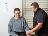 RehabCo clinician examining a worker’s shoulder during early intervention