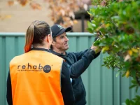 RehabCo consultant observing a worker using a pole pruner on site